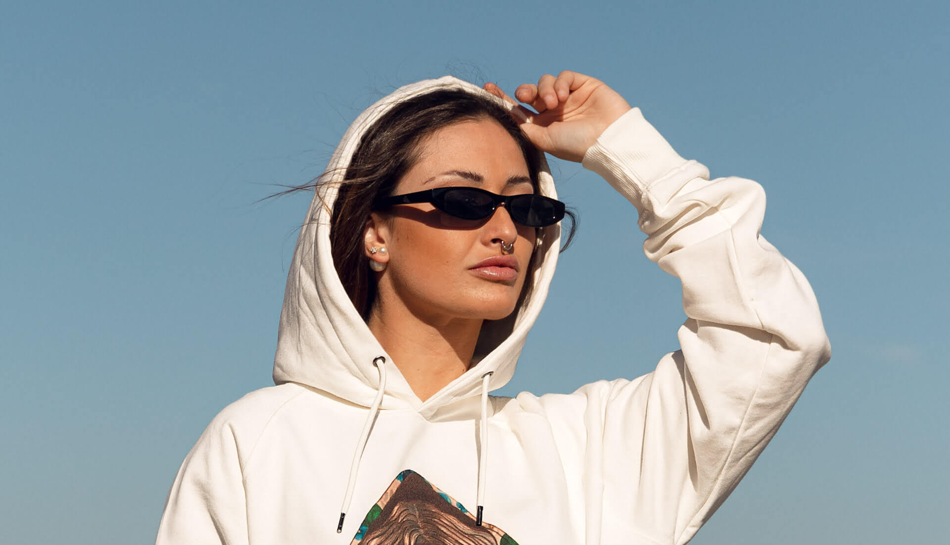 Chica con unas gafas de sol posando con una prenda de la marca Siempre Viva